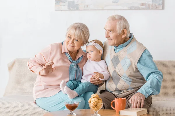 depositphotos_223171824-stock-photo-adorable-grandparents-sitting-sofa-toddler