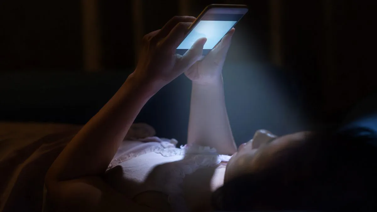 Niño-con-celular-en-la-cama-de-noche